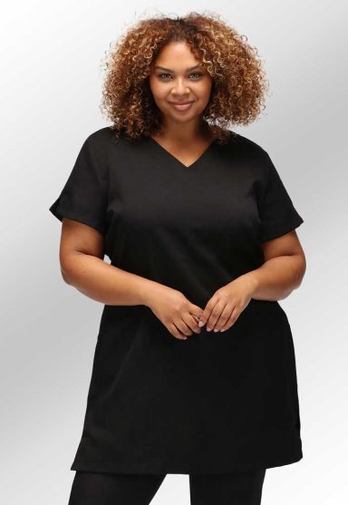 Woman with curly hair wearing a black V-neck top, smiling at the camera.