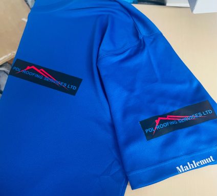Blue shirt featuring logo with red mountain graphic and text on black patches.